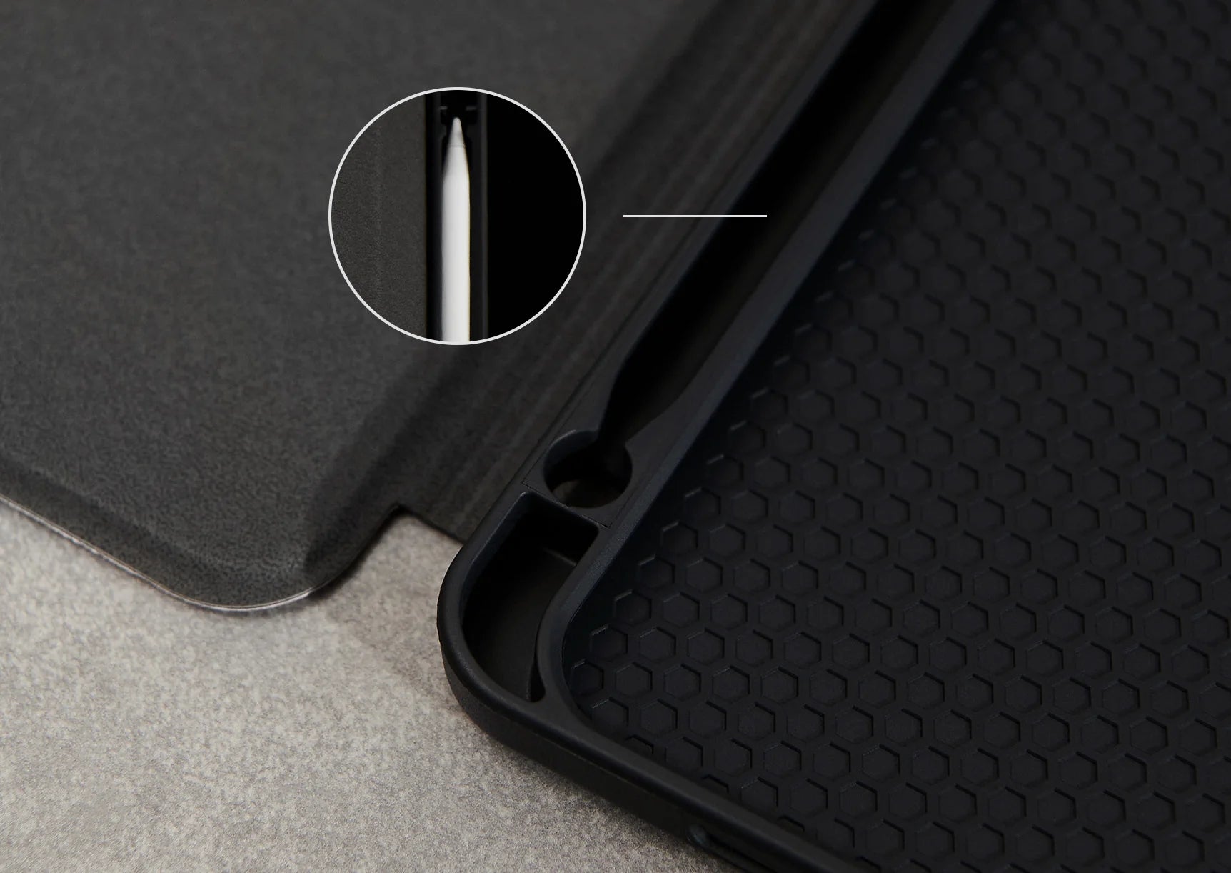 a close-up view of a black object, possibly a phone case or stand, with a small hole in it.